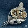 Two-Rose Floral Bouquet Brooch with Textured Leaves<br/><br/>Light surface wear and discolouration are visible.