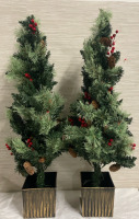 Two prelit and predecorated Christmas trees in planters