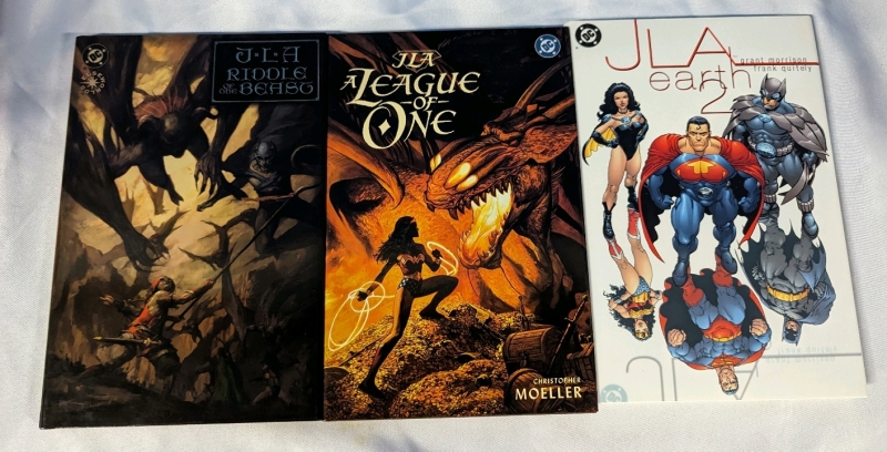 3 Justice League of America Hardcover Comic Books. "Riddle of the Beast", "A League of One", and "Earth 2". Full-Colour. 10.5" by 7"