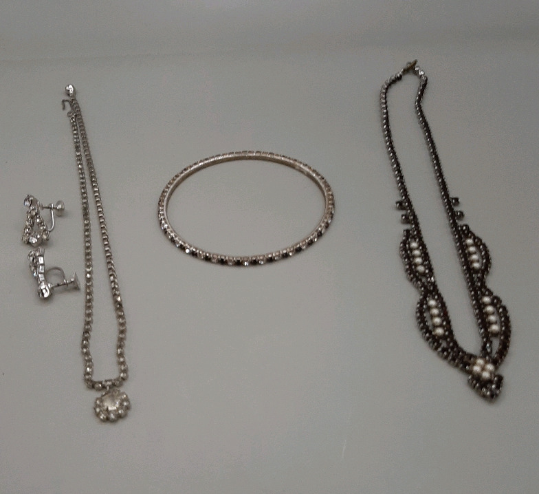 Vintage Costume Jewellery One 16" Necklace with Clear Stones & Screw Back Earrings One 16" Necklace with Black Stones and Pearl's & a 2.75" Diameter Bracelet with Blue & Clear Stones Clear stone Necklace needs repairs to the clasp