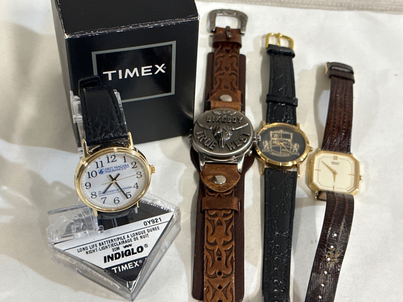 4 Watches Timex Indiglo First Niagara Insurance With Stand and Box Black and Gold Coty of Niagara Falls Brown White and Gold Seiko Made in Canada and Biker Boy True West Biker Watch