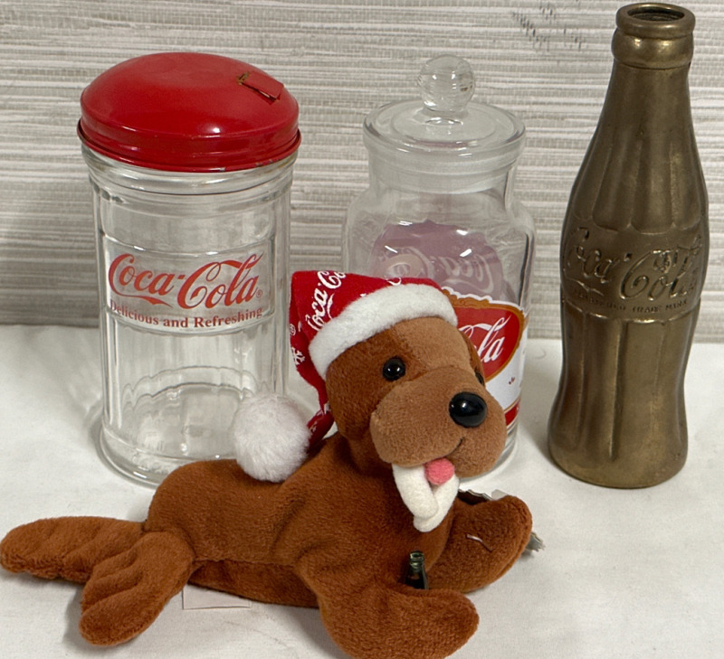 4 Piece Coca-Cola Collectors Lot Including a 7&rdquo; Brass Coke Bottle 5.5&rdquo; Glass Sugar Dispenser and Cookie Jar With 1998 Coca Cola Walrus Beanbag Plush Stuffed Animal Brown With Hat