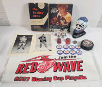 NHL Hockey Memorabilia Lot . 2 Beehive Cards , 2 Books , Sabres Puck , 8 Caps , Avalanche Ring , Mini Figs holding Cup , Wings Towel , Avalanche Goalie Helmet