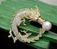 Brooch Featuring a Chinese Dragon Adorned with Rhinestones Chasing A Faux Pearl Approximately 2 x 2 Inch