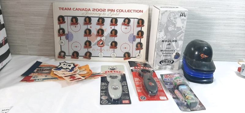 Lot of Sports Memorabilia | Includes Team Canada 2002 Pin Collection (4 Pins Missing), 2003 McDonalds Eric Moulds Collectors Edition Figure, Miniature Baseball Helmets, Vintage Patches and Banners, 2 Talking Bottle Openers & Football Candy Dispenser