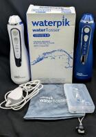 2 As-New WATERPIK Water Flossers Cordless Advanced 2.0, 1 Charger, 2 Bases, 4 Tips, Case & Carry Bag