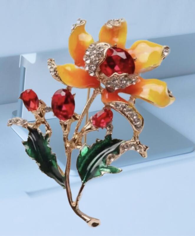 Elegant Rhinestone Flower Brooch with Red Gemstone Cabochons at Center & Green Leaves Vibtant Yellow and Tangerine Petals approximately 1.5 x 2&rsquo;&rsquo; stock photo added