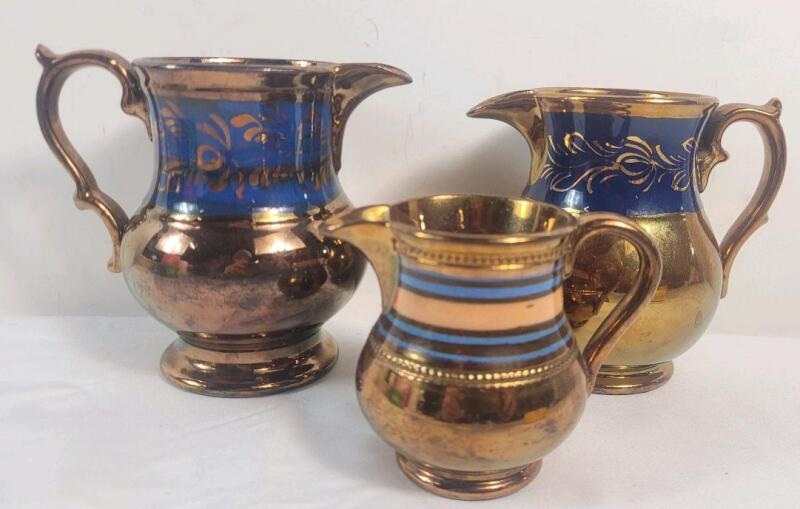 Three (3) Lusterware Water Jugs . Measures 3 &frac14;" , 4 &frac12;" & 4 &frac34;" tall .